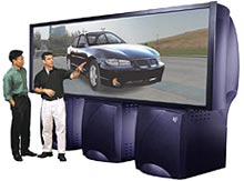 Two men viewing automobile on screen of SGI Reality Center 3300W visualization system